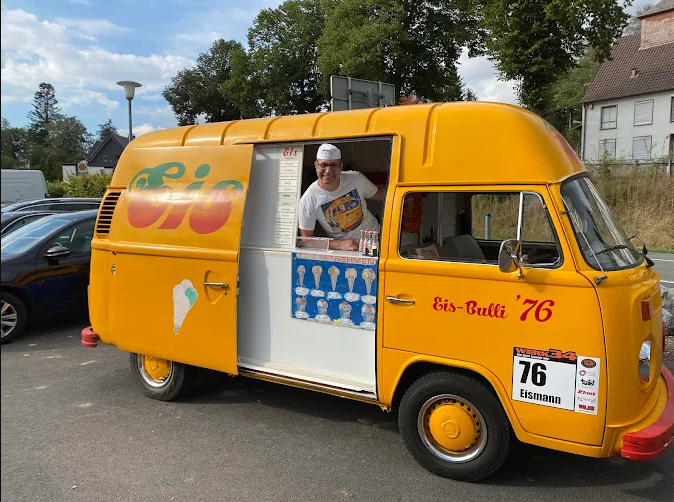 Der orange Eis-Bulli 76 mit geöffnetem Verkaufsfenster